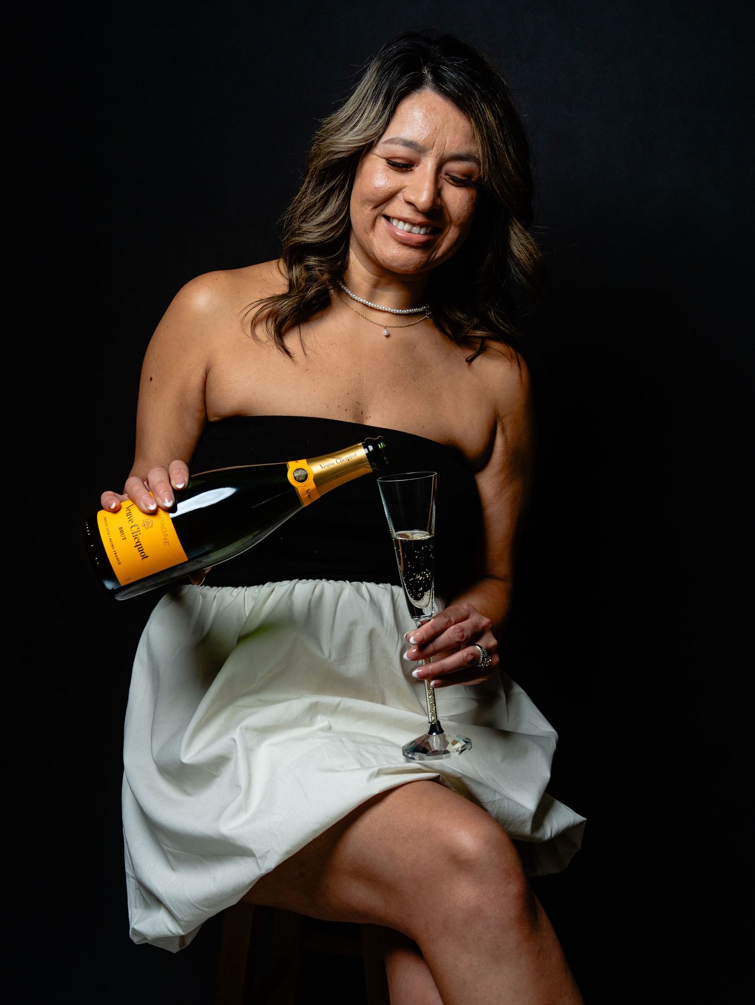 A sequence of champagne pouring photos showing someone in a white dress holding a glass against a dark background.