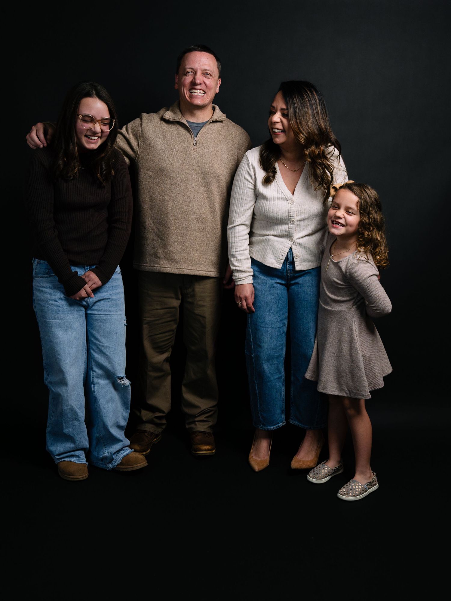 A family portrait series against a dark background showing different cropped compositions and poses in casual attire.