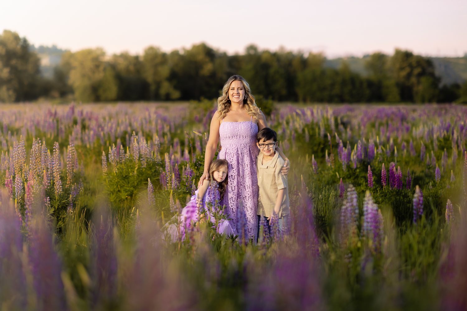 A mom poses for a photo in a field of dense purple lupine near Seattle.