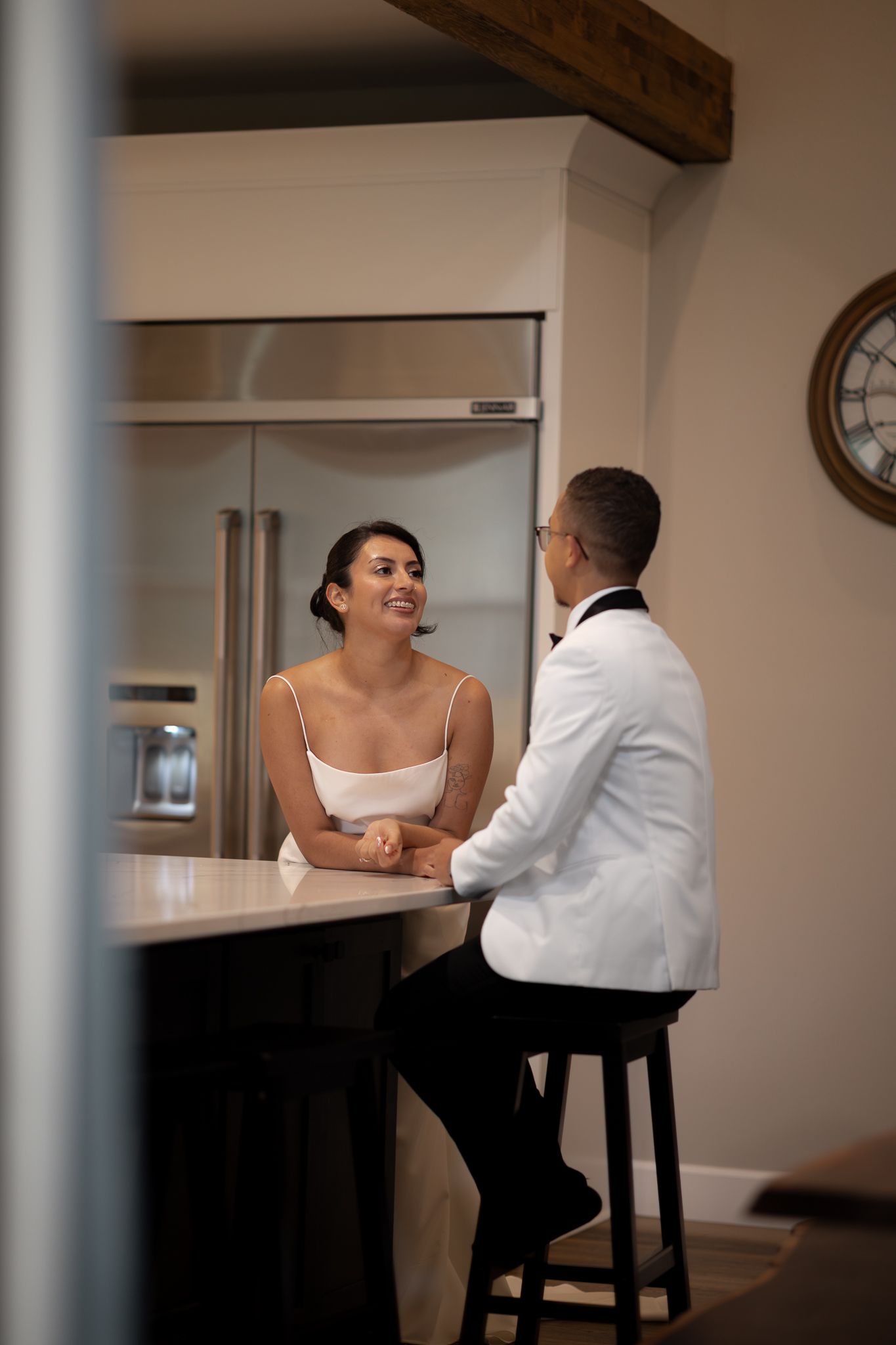 Bride and groom sit at the kitchen counter of their airbnb in Ashford, Washington after their ceremony along the Nisqually River.