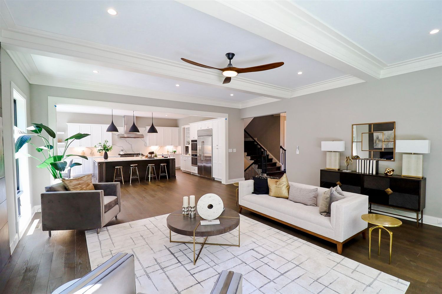 Spacious living area with white walls and ceiling fan showcasing minimalist interior design.