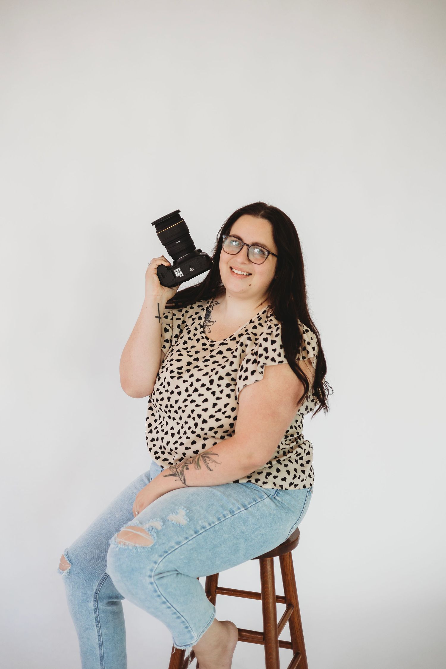 Portrait of Audrey Jo Photo, Michigan Photographer, smiling with camera in hand and looking at the camera.