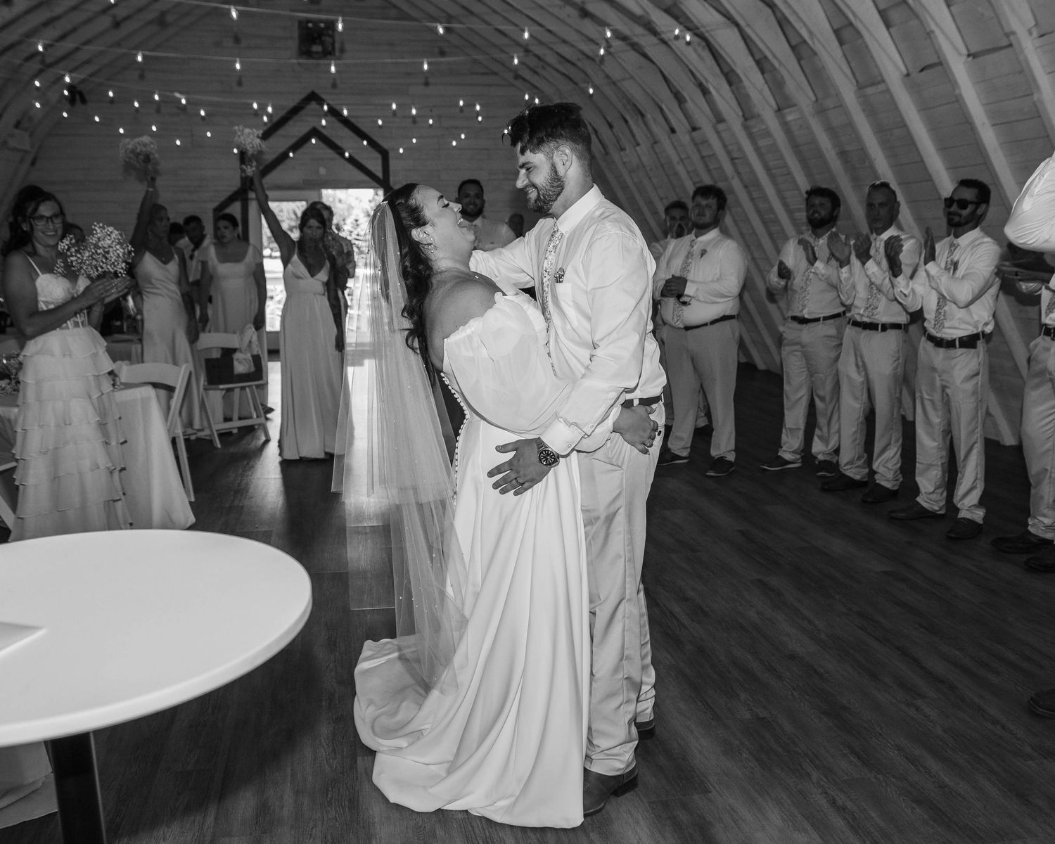 Bride and Groom after wedding ceremony laughing while bridesmaids and groomsmen laugh and cheer in the background in Sherwood,MI