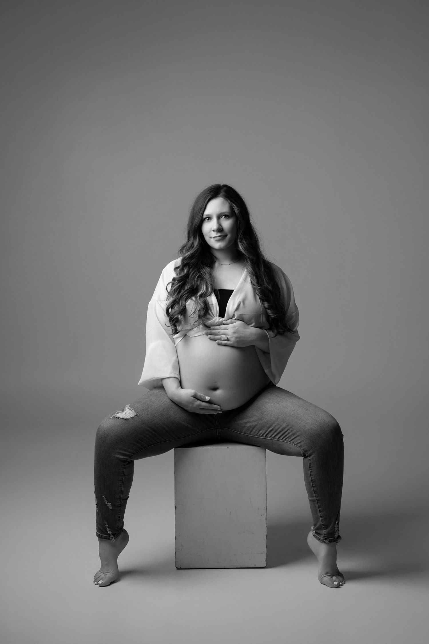 Black and white photo series showing minimalist poses with a person sitting on boxes against a simple backdrop.