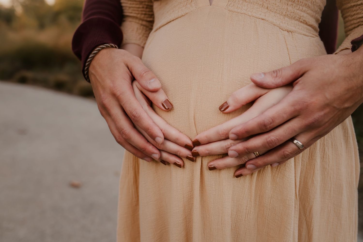 Close up maternity photo of mother's belly with hands on the belly.