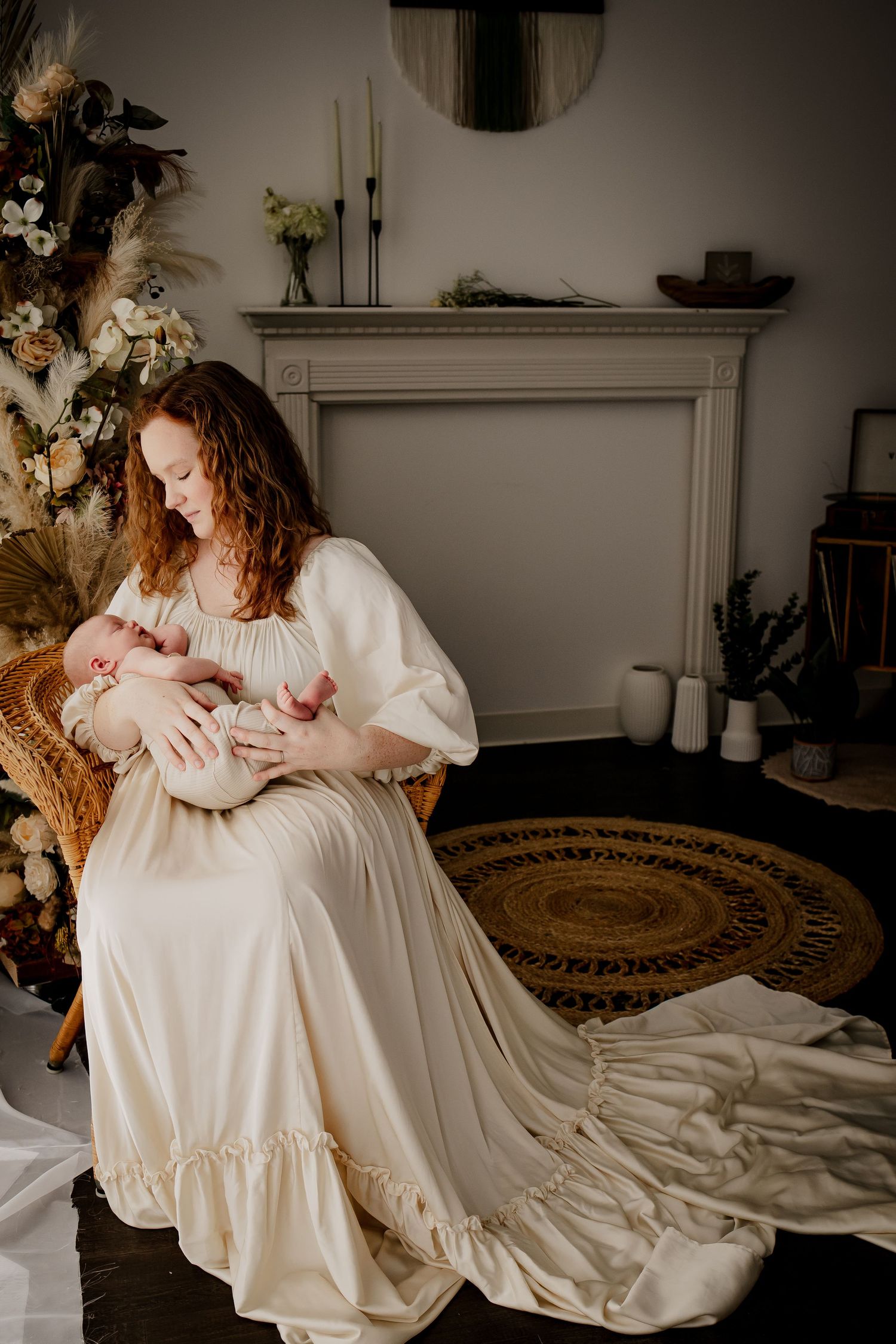 Mom holding her newborn baby in a boho newborn session by Fully Known Services, wearing a long, beautiful gown.