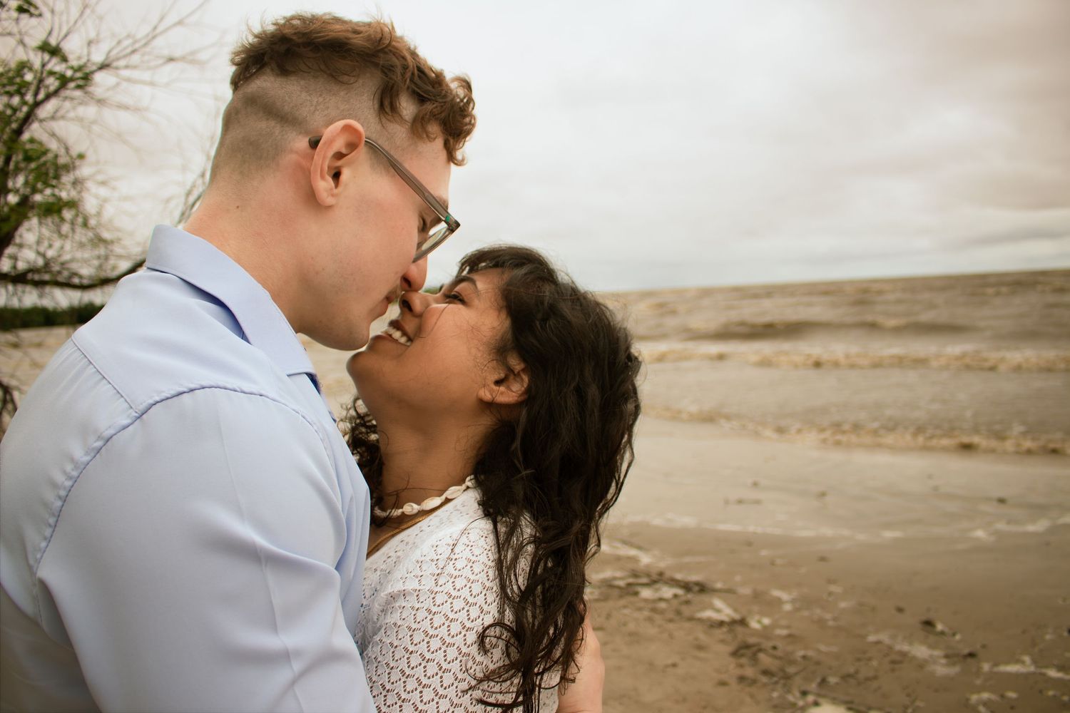 couple touching noses at the beach