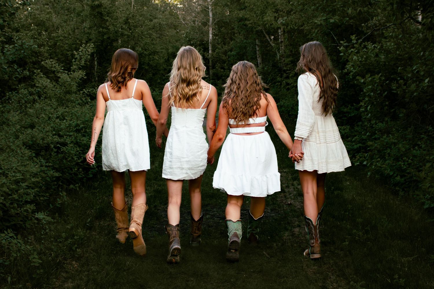 four female friends posing in the forest