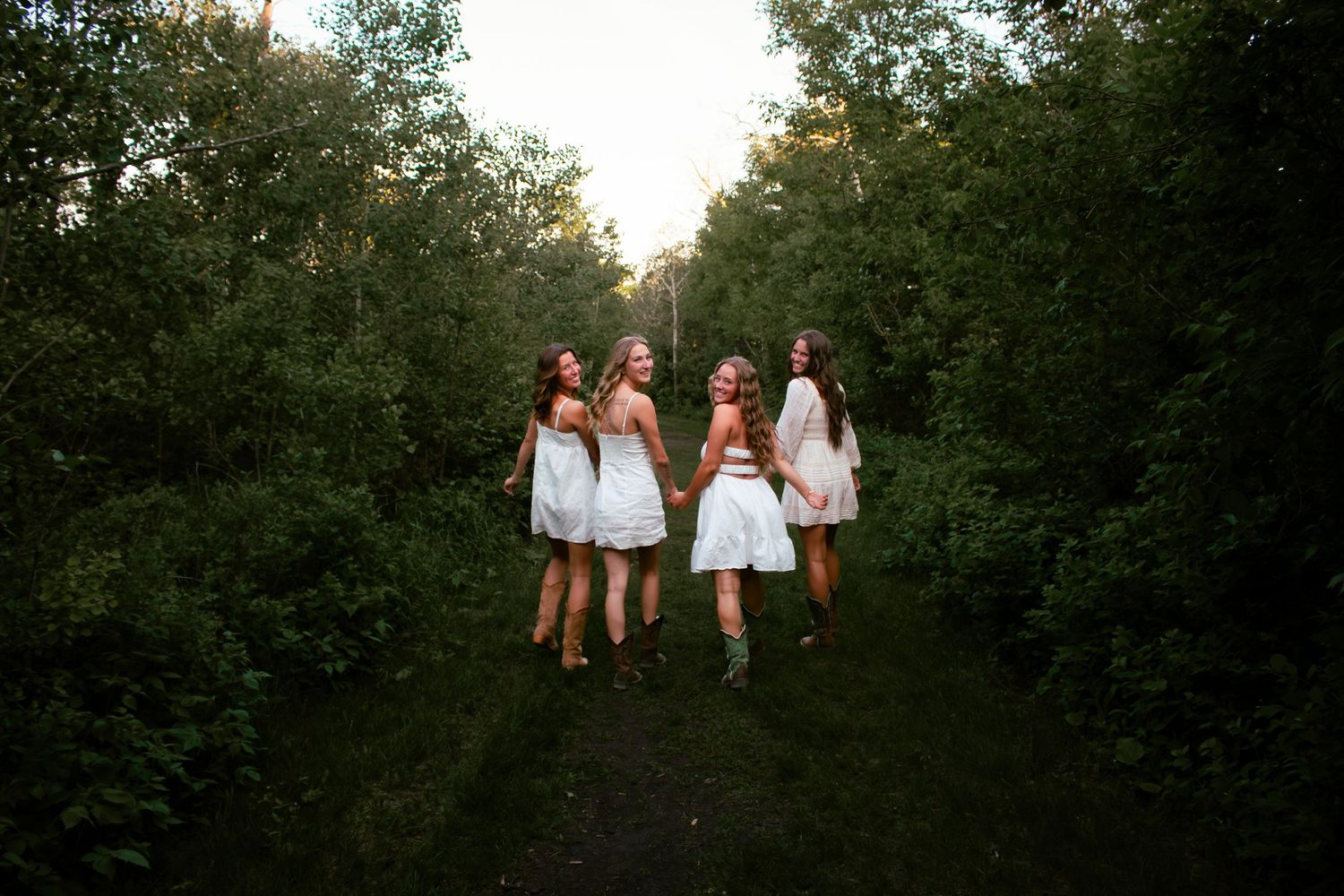 four female friends posing in the forest