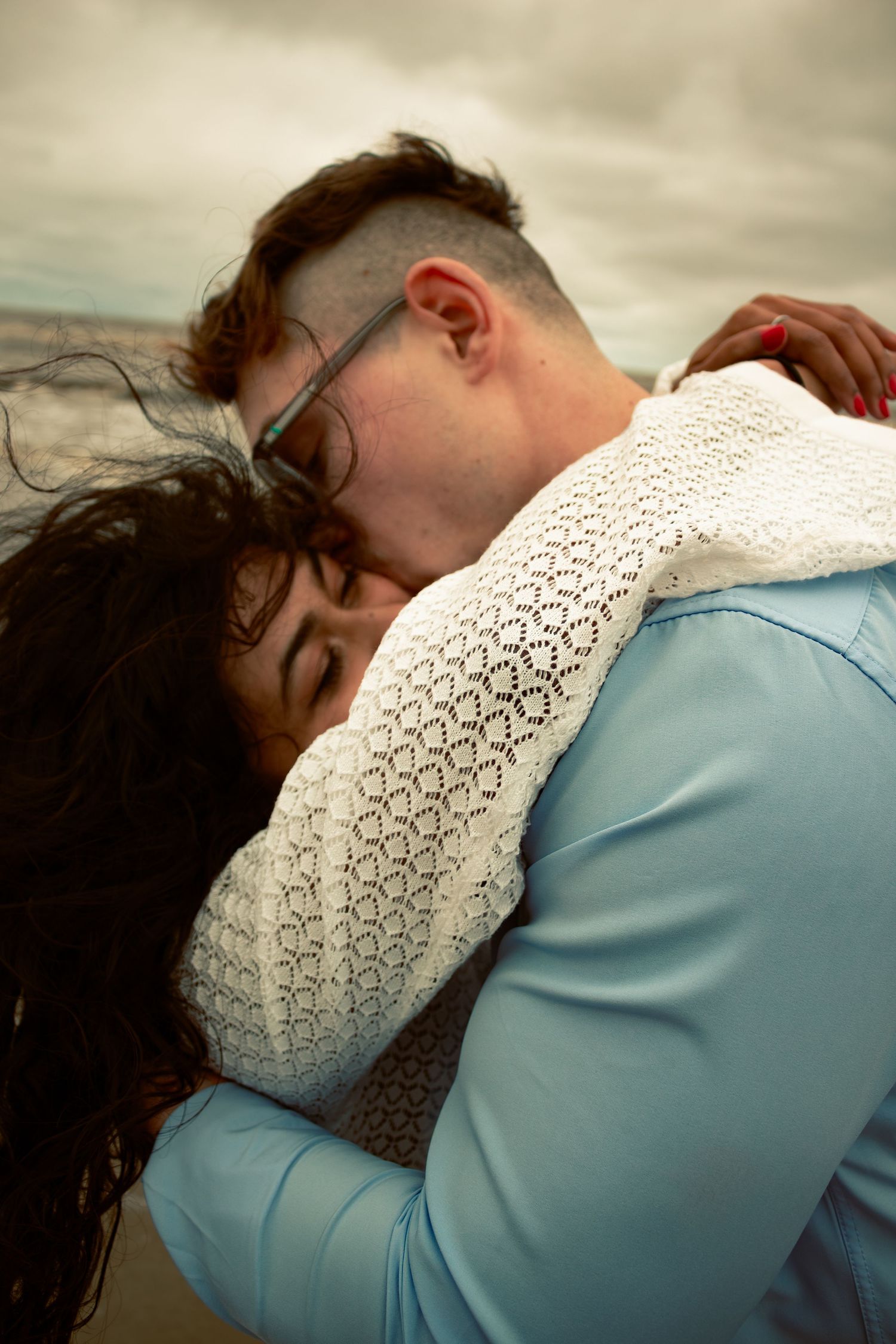 couple embraced in a hug at the beach