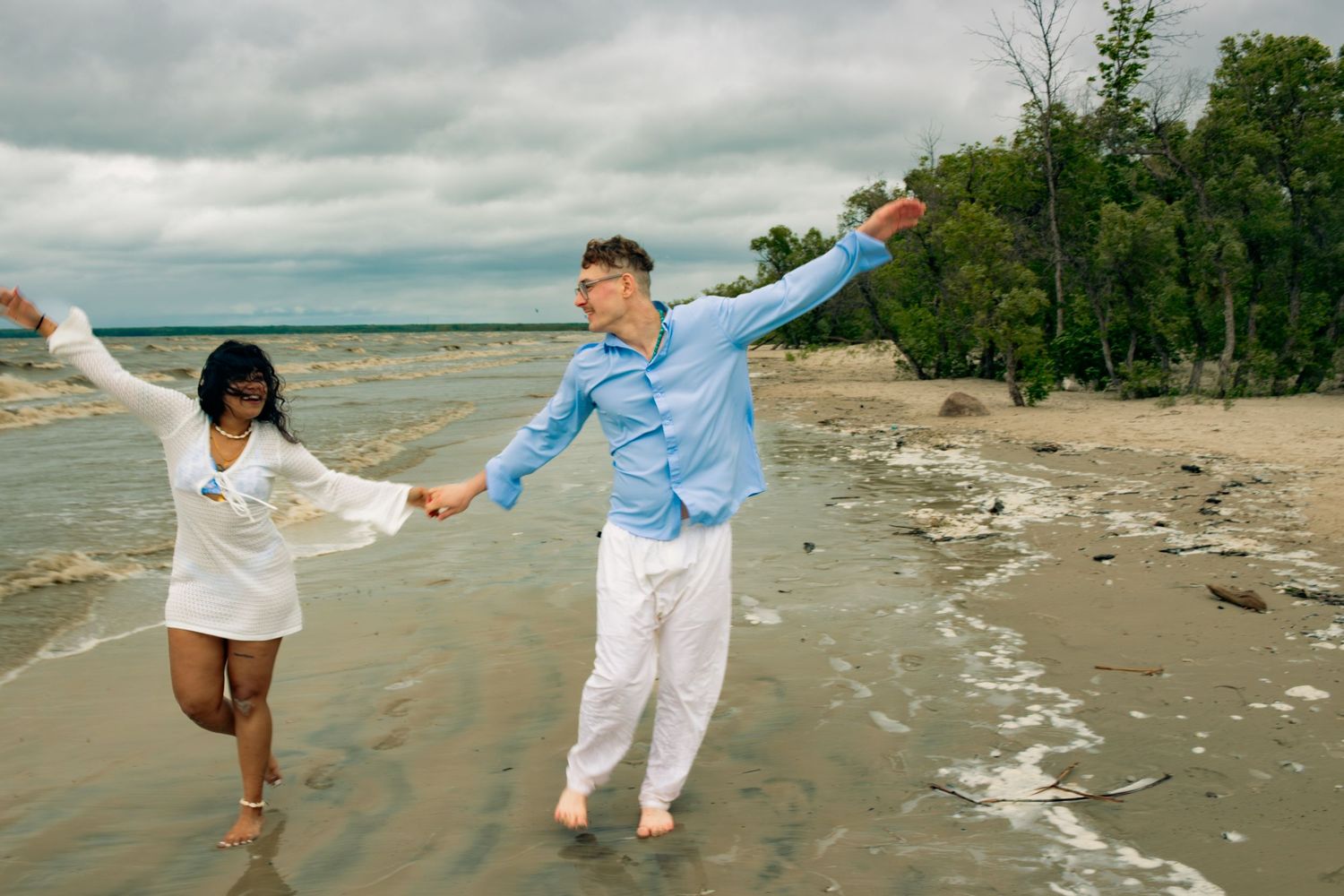 couple holding hands and walking at the beach