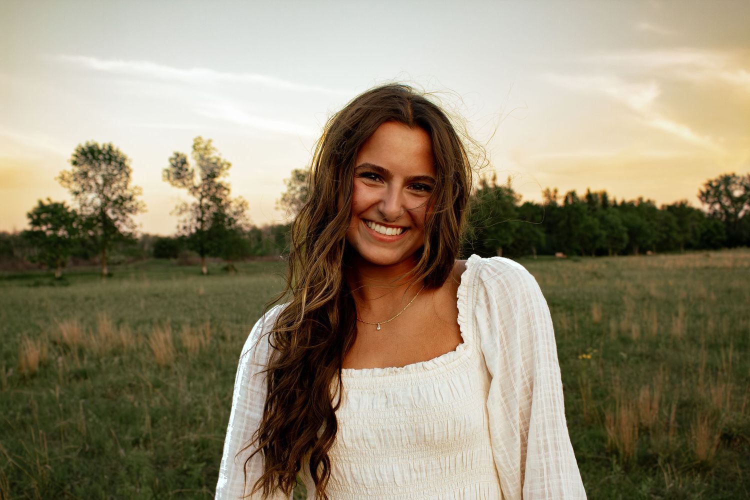 young woman in a field smiling
