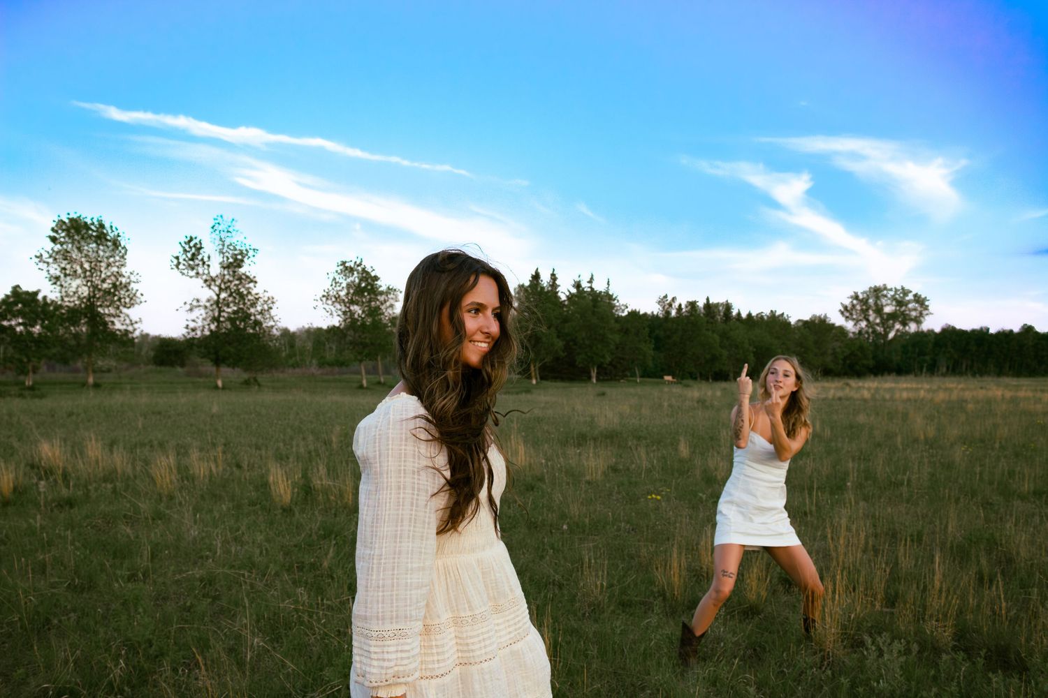 young woman posing in a field at sunset