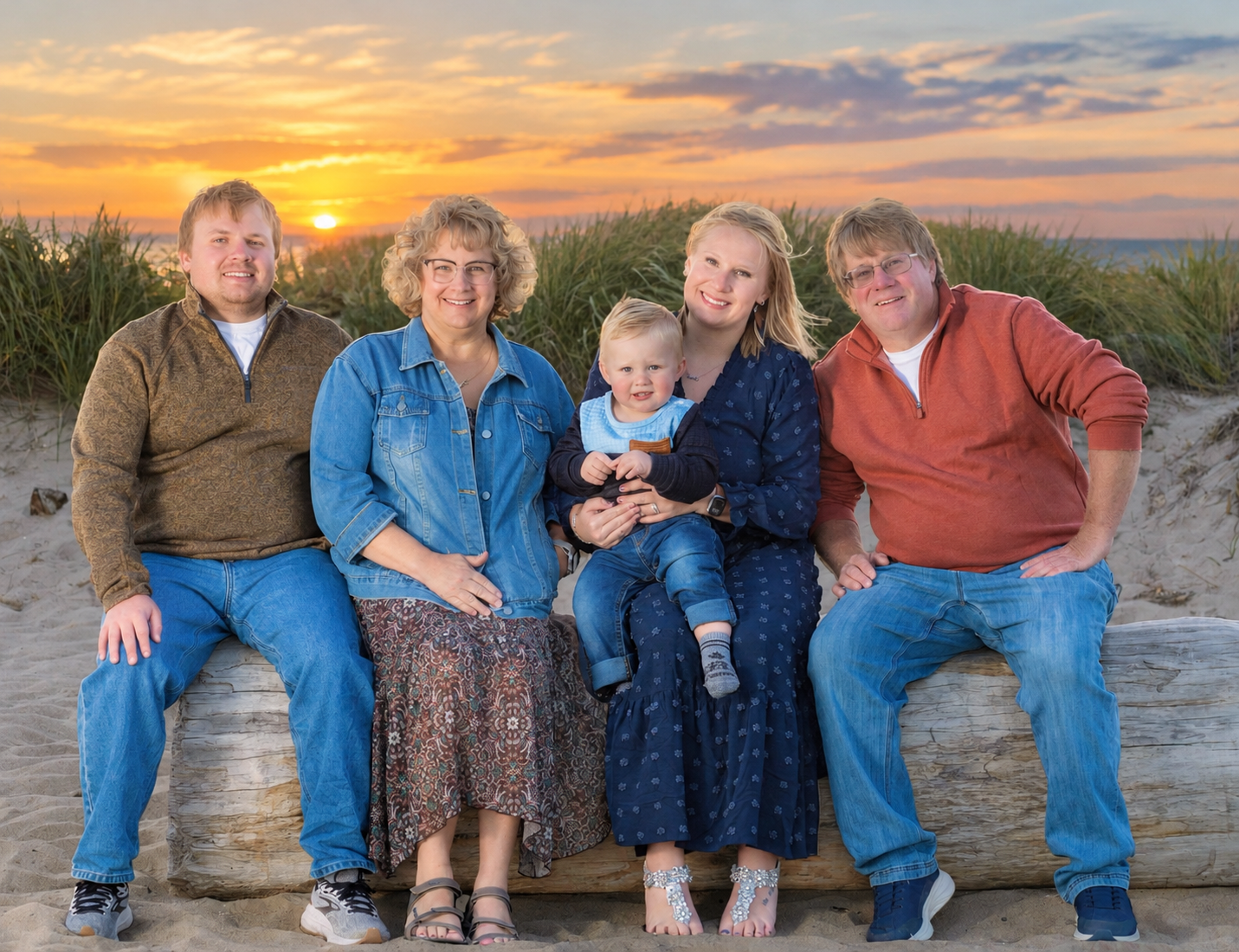 Family on log with the sunset in the background