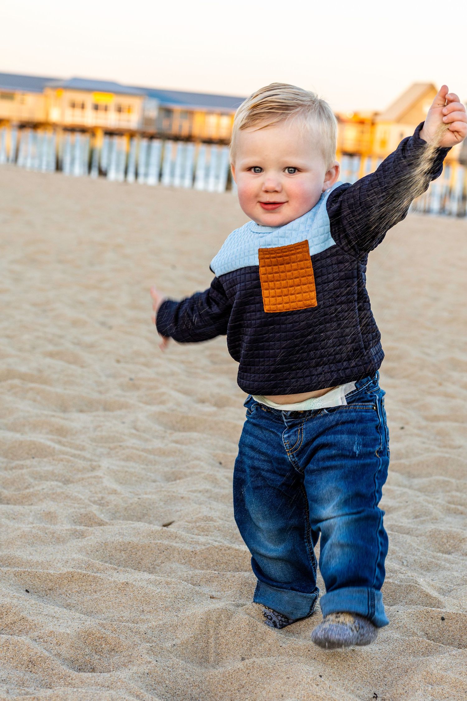 Baby on the beach with the pier in the background