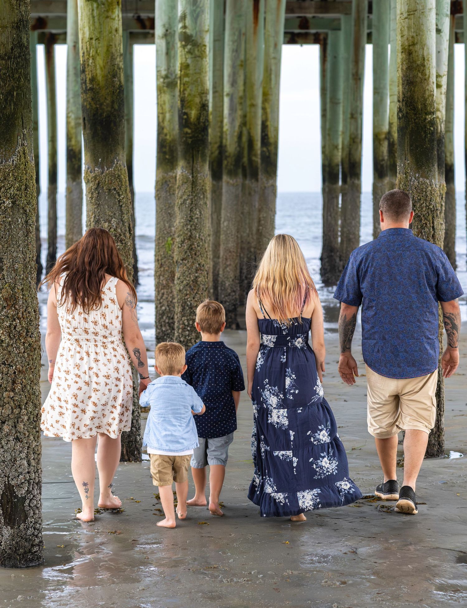 Family walking under the old orchard beach pier