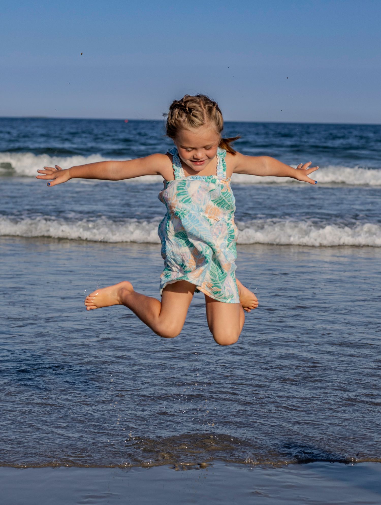 Young girl jumping by the water