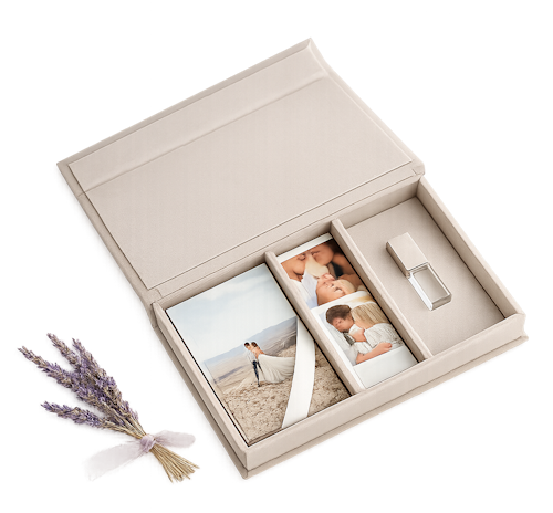 Luxury beige wedding photo box with printed photos, ribbon, and USB drive beside lavender sprigs.