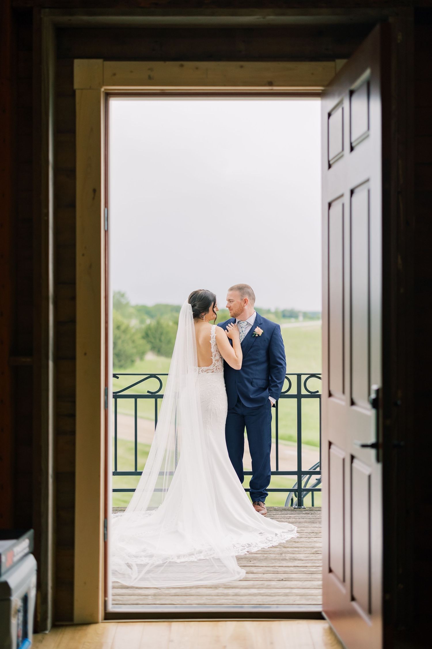 A series of romantic wedding photos showing a couple in formal attire standing on a balcony overlooking scenic countryside.