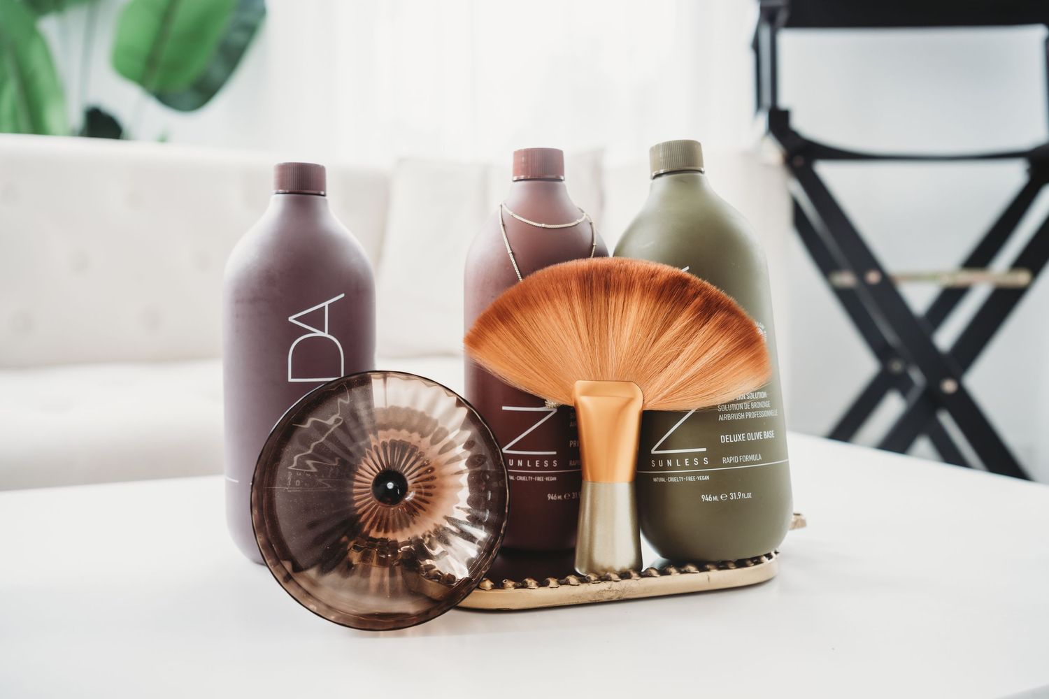 Professional hair care products displayed on white table in bright salon studio.