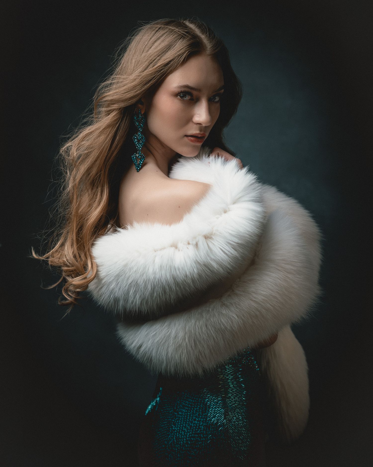 A woman wearing a white fur wrap and teal sequin dress with matching earrings poses against dark background.