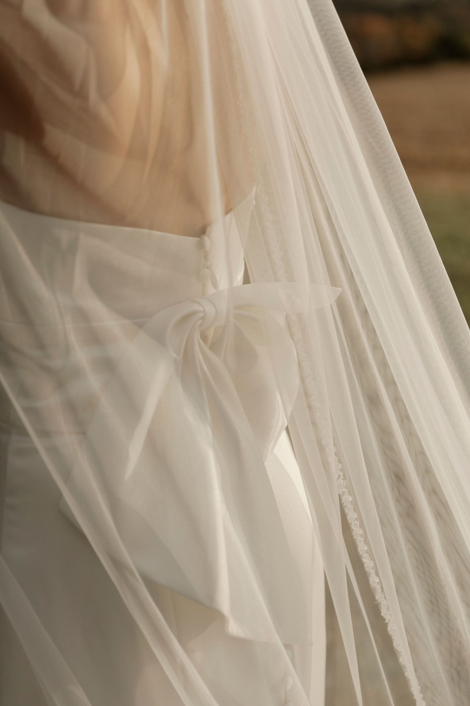 A delicate white wedding veil with soft pleats and sheer fabric creates an ethereal bridal detail.