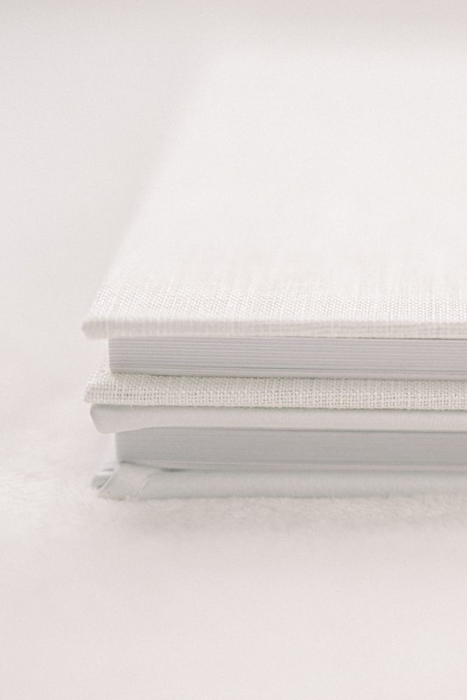 A close-up view of white book spines showing neat binding and edges against a light background.