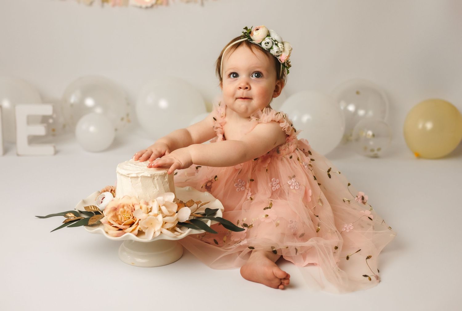One year-old baby celebrates her birthday with a blush, floral cake smash session, captured by Charlottesville newborn photographer.