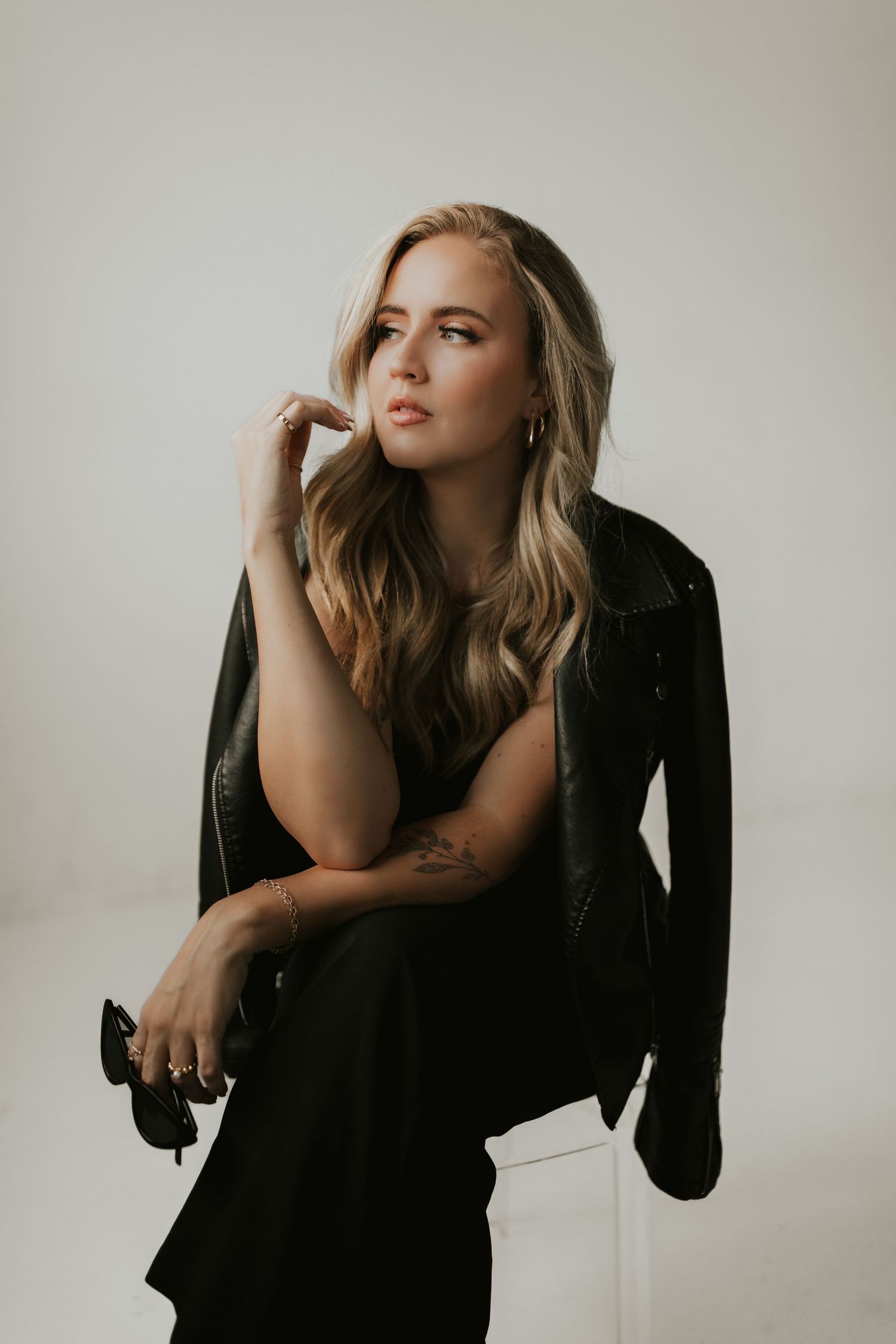 Artistic portrait series showing model in black clothing against light background striking different dramatic poses.