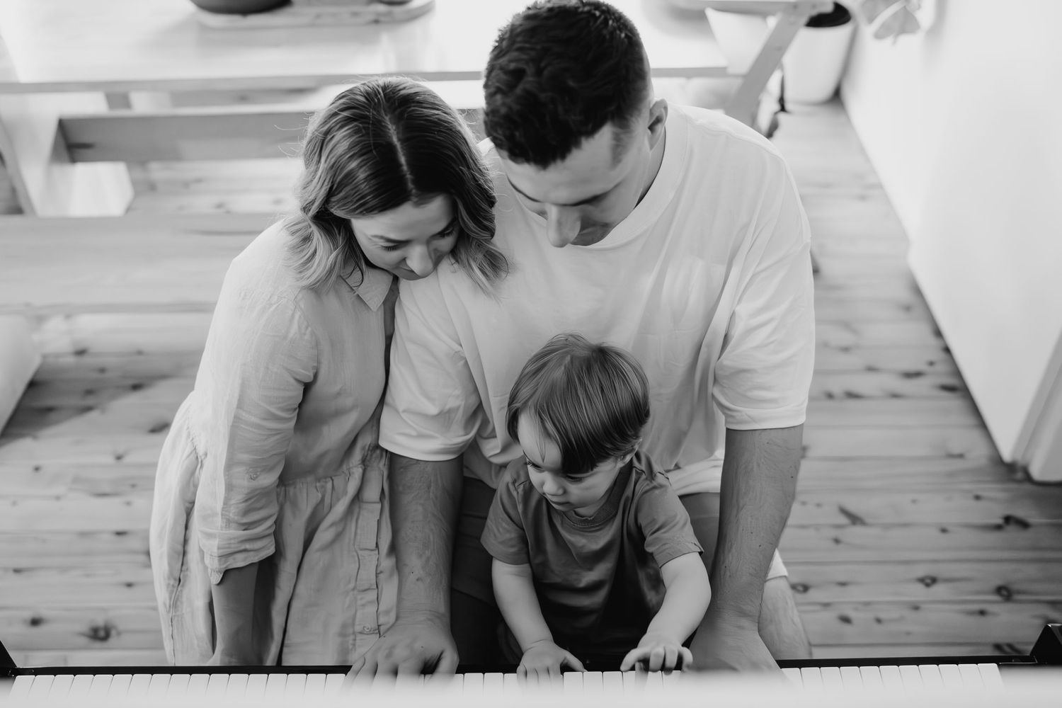 Black and white portrait of a family leaning together in tender moment.