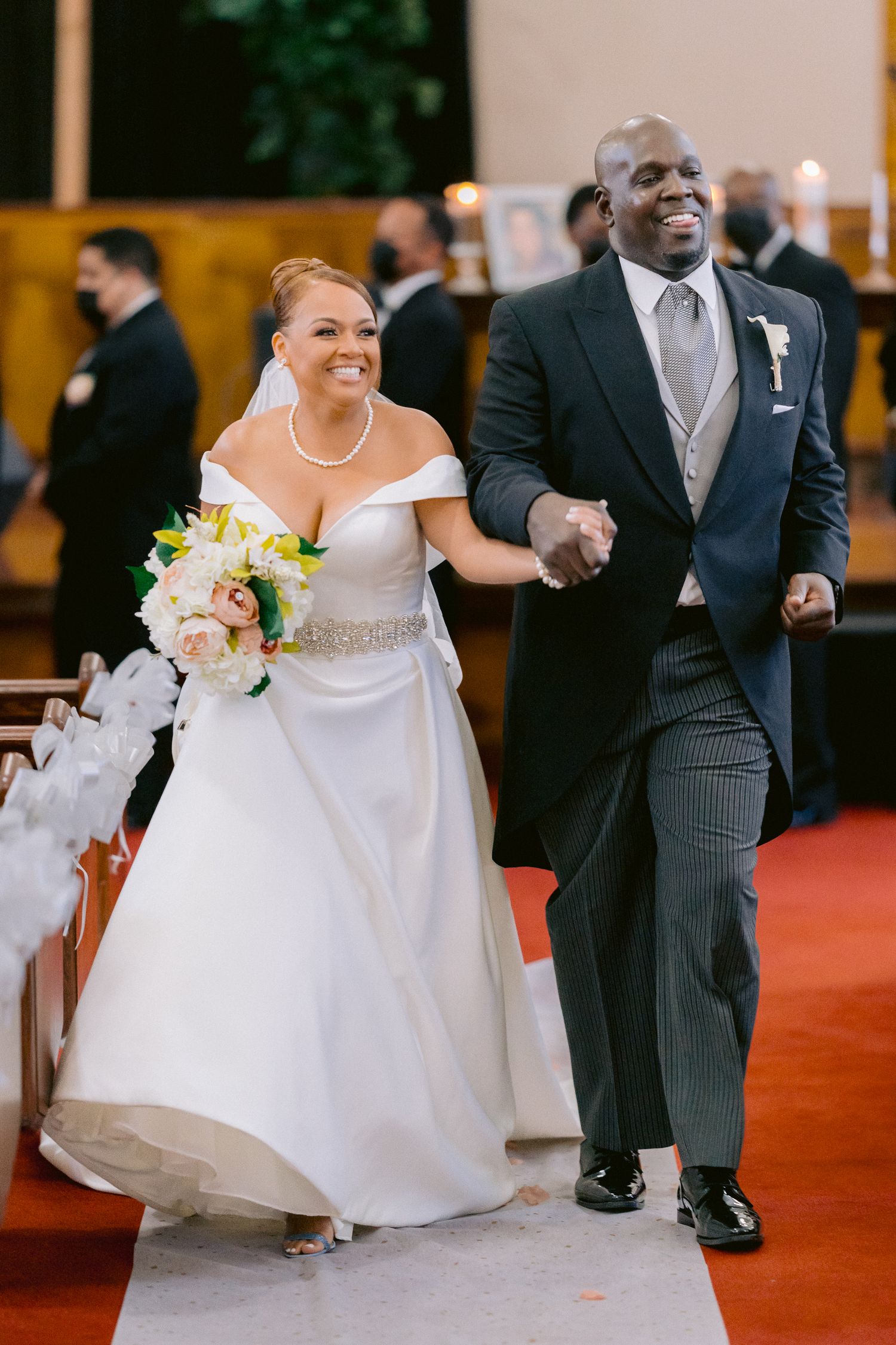 Wedding celebration captures candid moments of laughter and love on a deep red carpeted floor. Tampa Wedding Photographer
