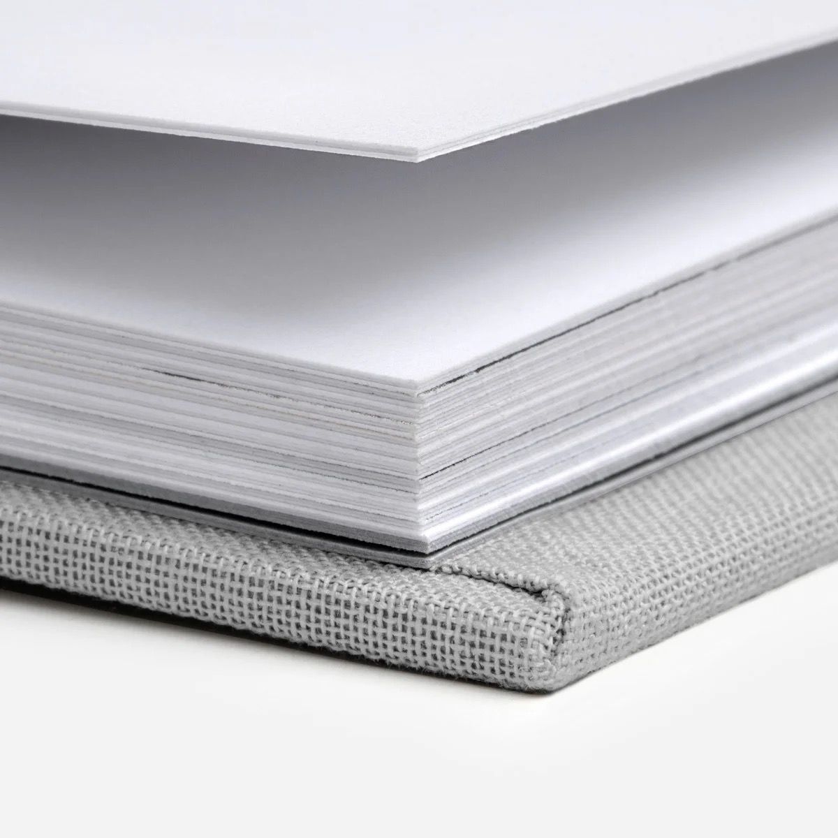 Close-up of white textured photo album pages showing layered edge detail.