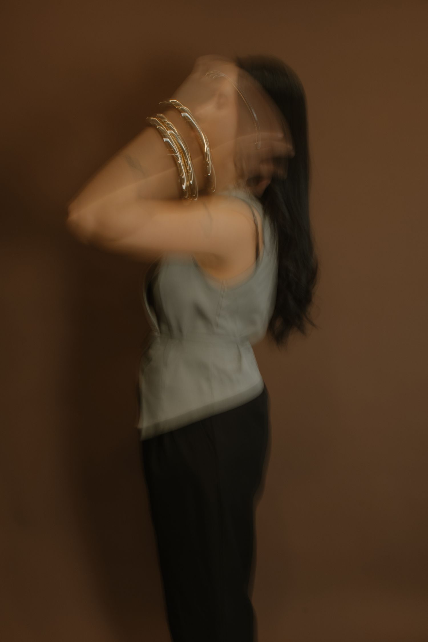 Artistic sequence of blurred dance movements in muted tones against a dark background.