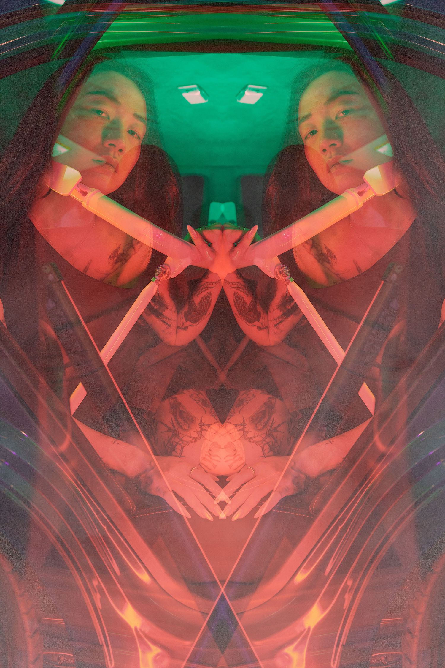 Abstract mirrored portrait of a woman inside a car, with red and green neon lighting forming a symmetrical pattern.