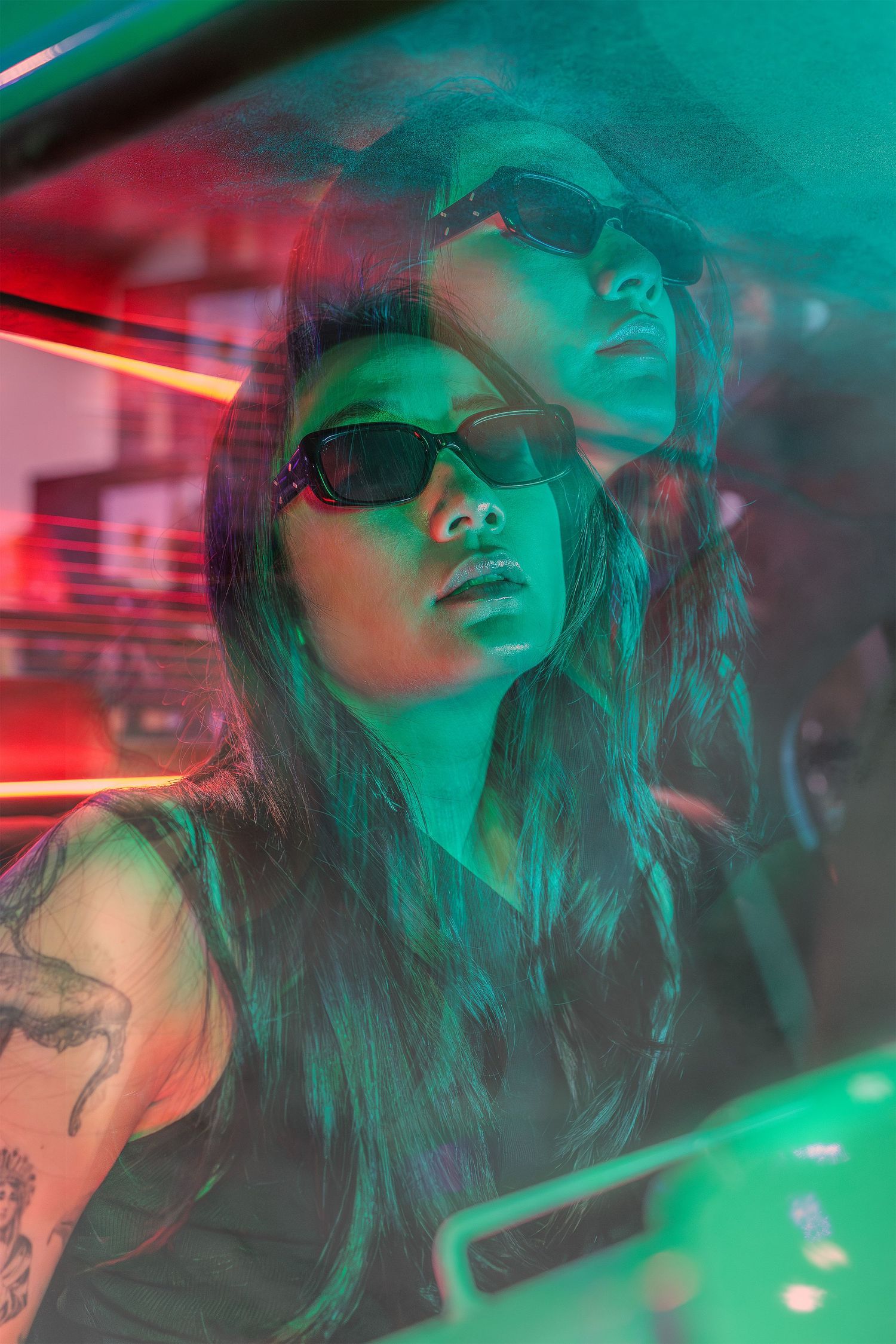 Neon portrait of a woman seen through a car window, with green and red reflections creating a double exposure effect