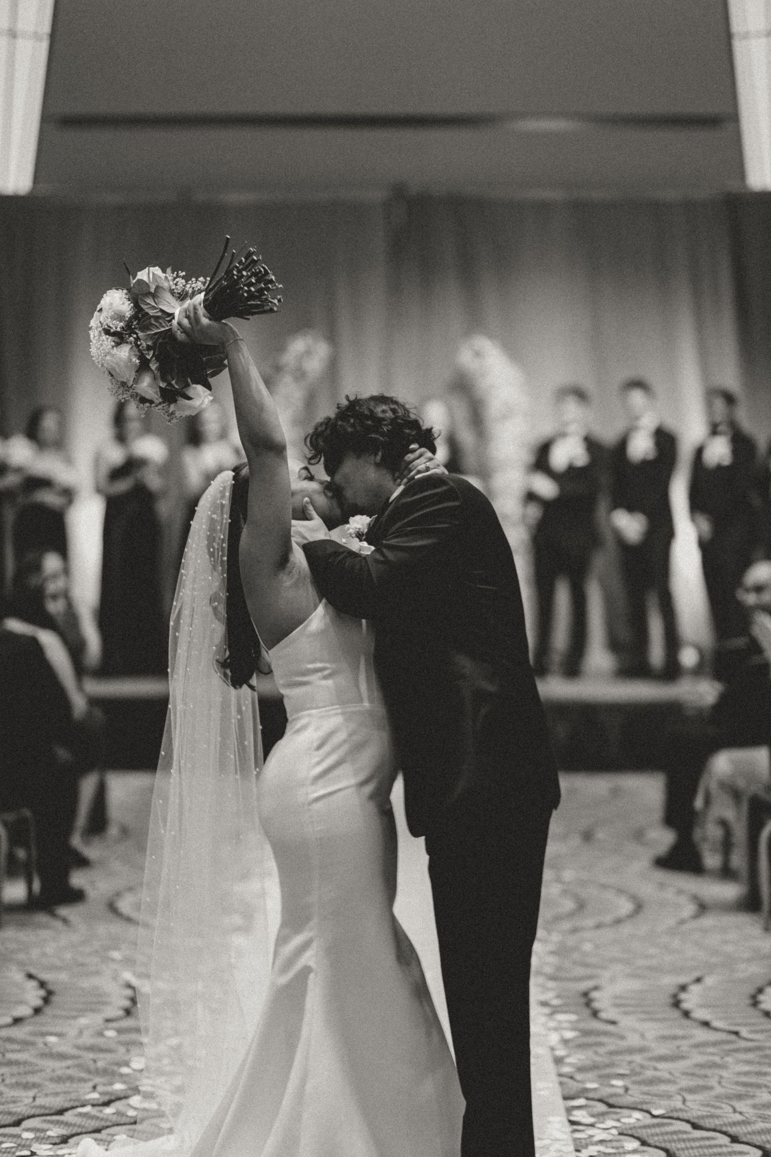 Romantic first dance sequence of newlyweds on a patterned ballroom floor.
