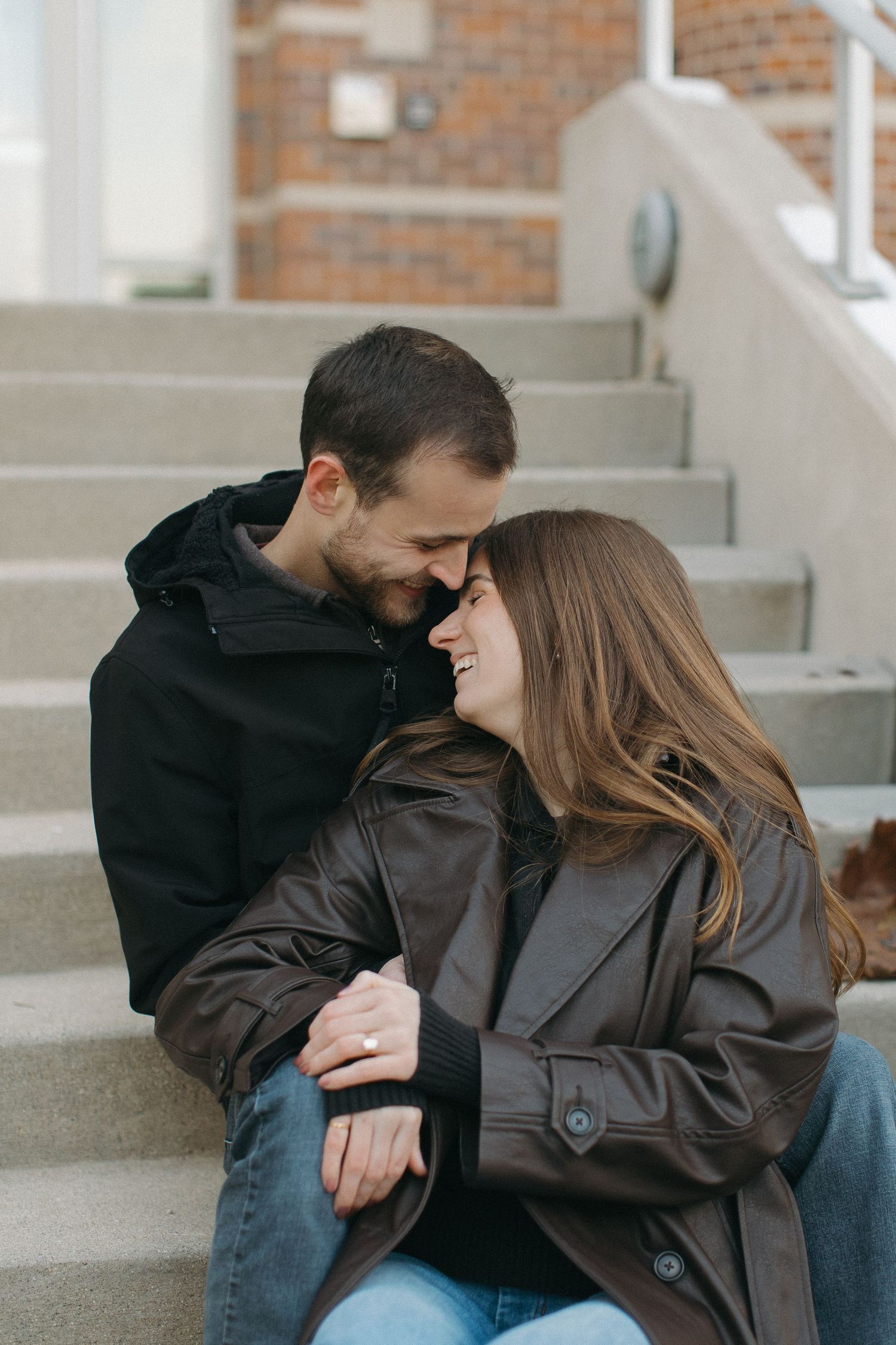 A romantic moment shared between a couple sitting on concrete steps.