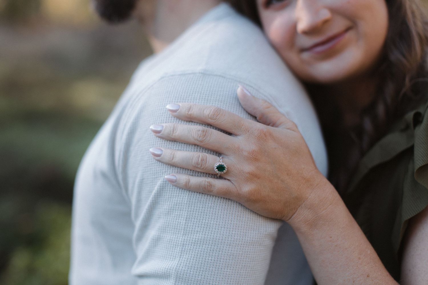 A close-up shot of an affectionate embrace outdoors.