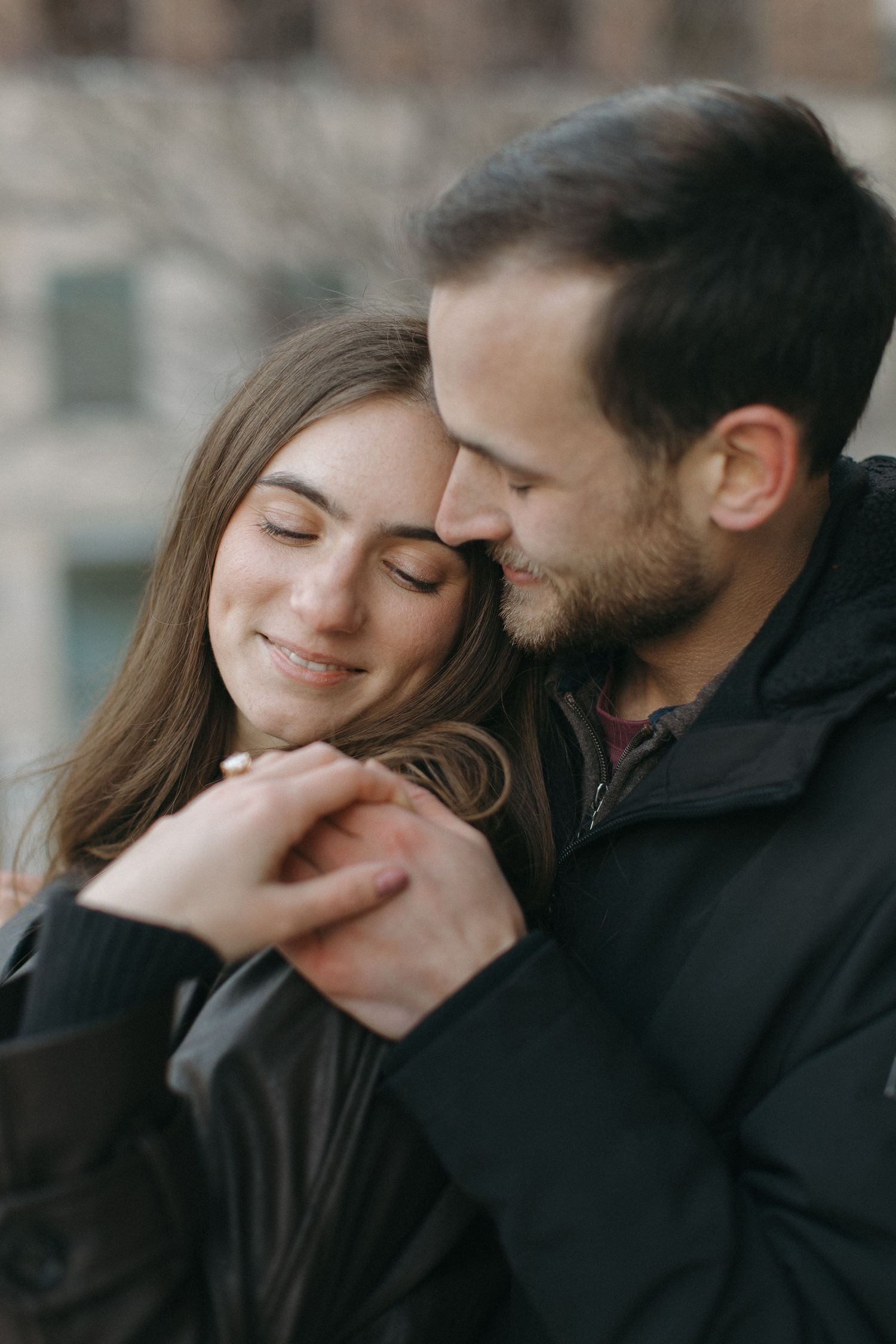 A tender moment between a couple in casual winter attire.