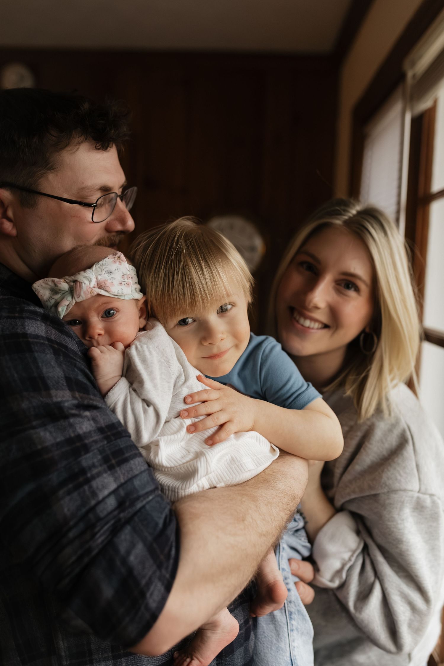 A family shares intimate moments together in a warmly lit indoor setting.