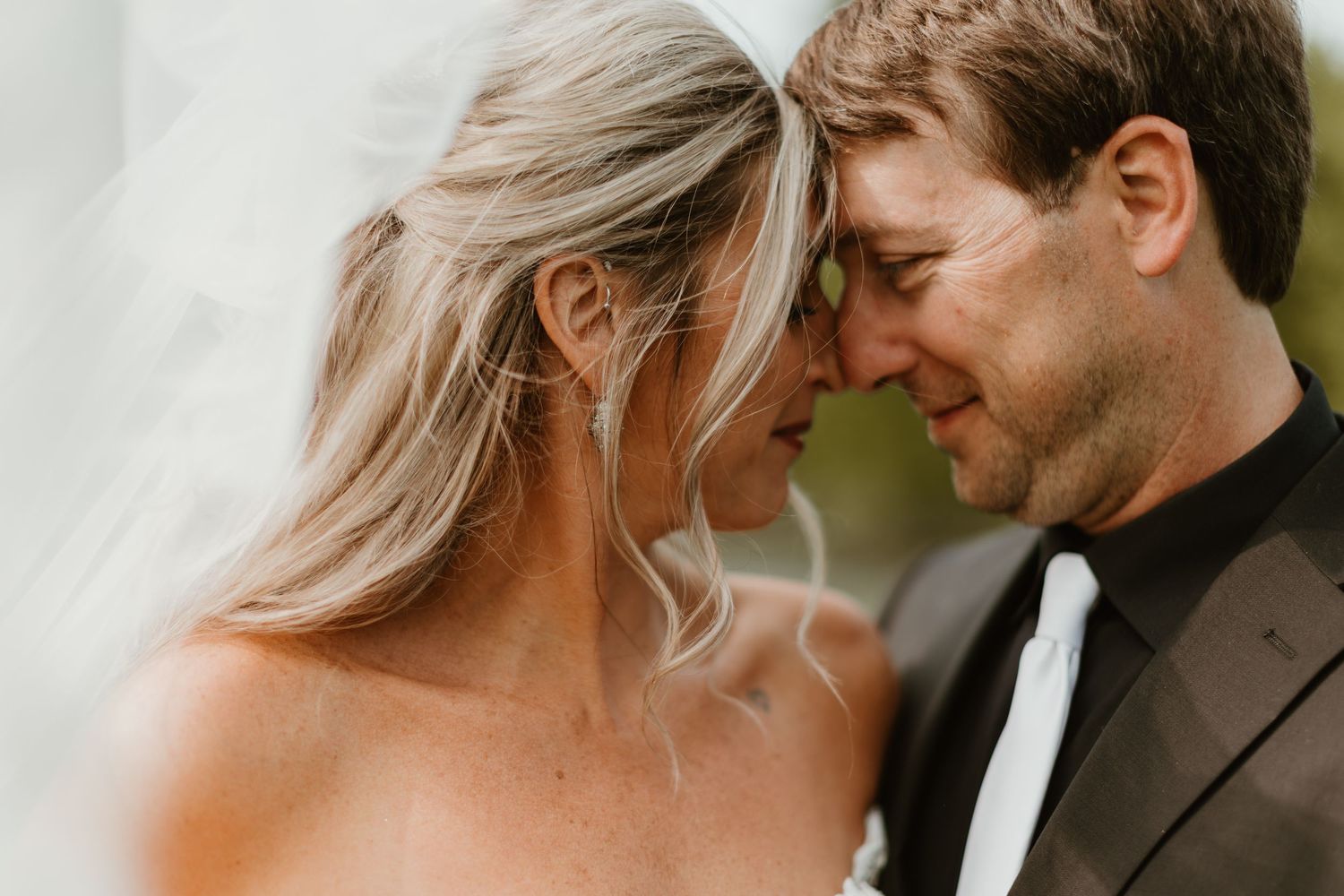 Intimate wedding portrait with couple in autumn outdoor setting.