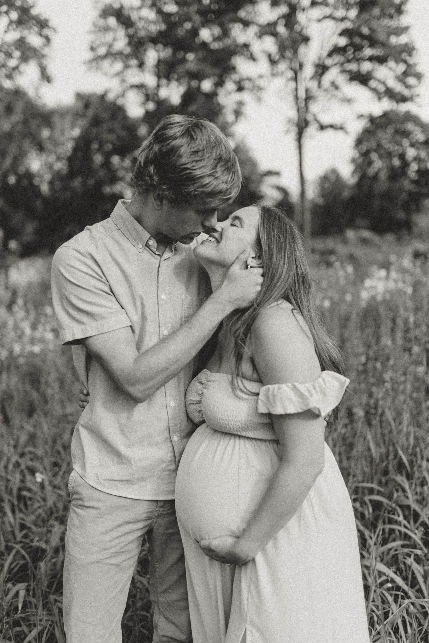 An intimate black and white maternity portrait showing tender moments between a couple.