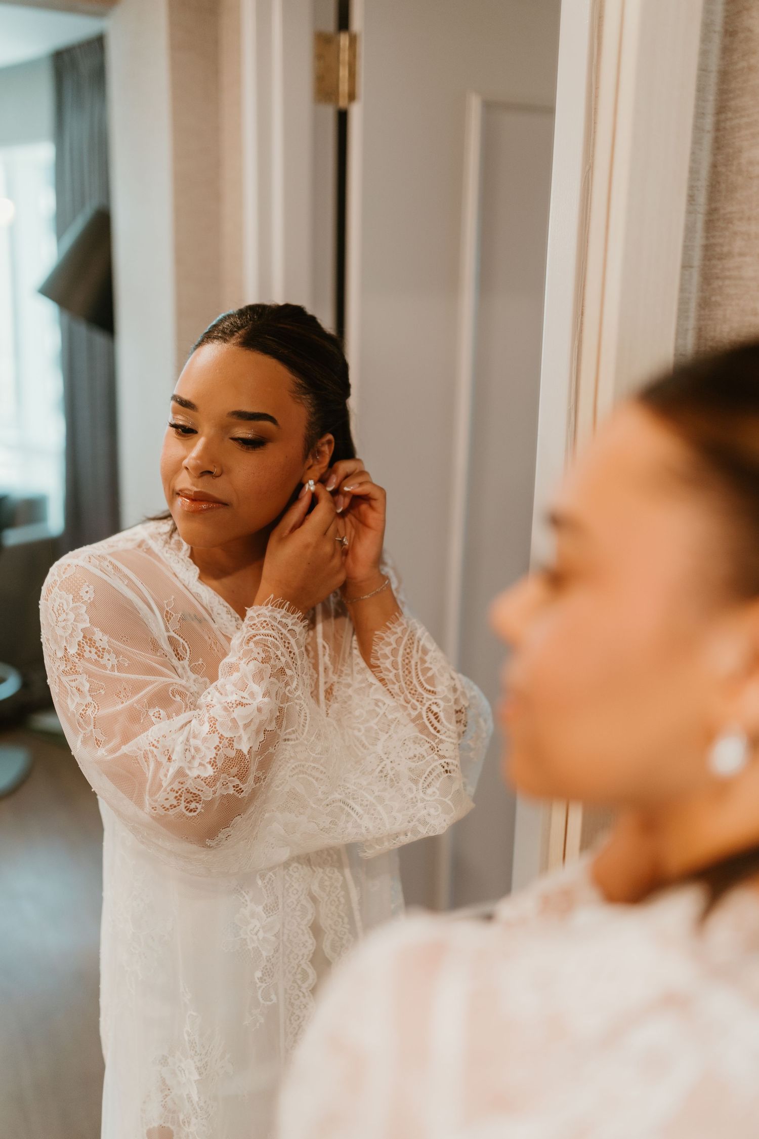 Close-up shots of a bride getting ready in an elegant lace-sleeved wedding dress.