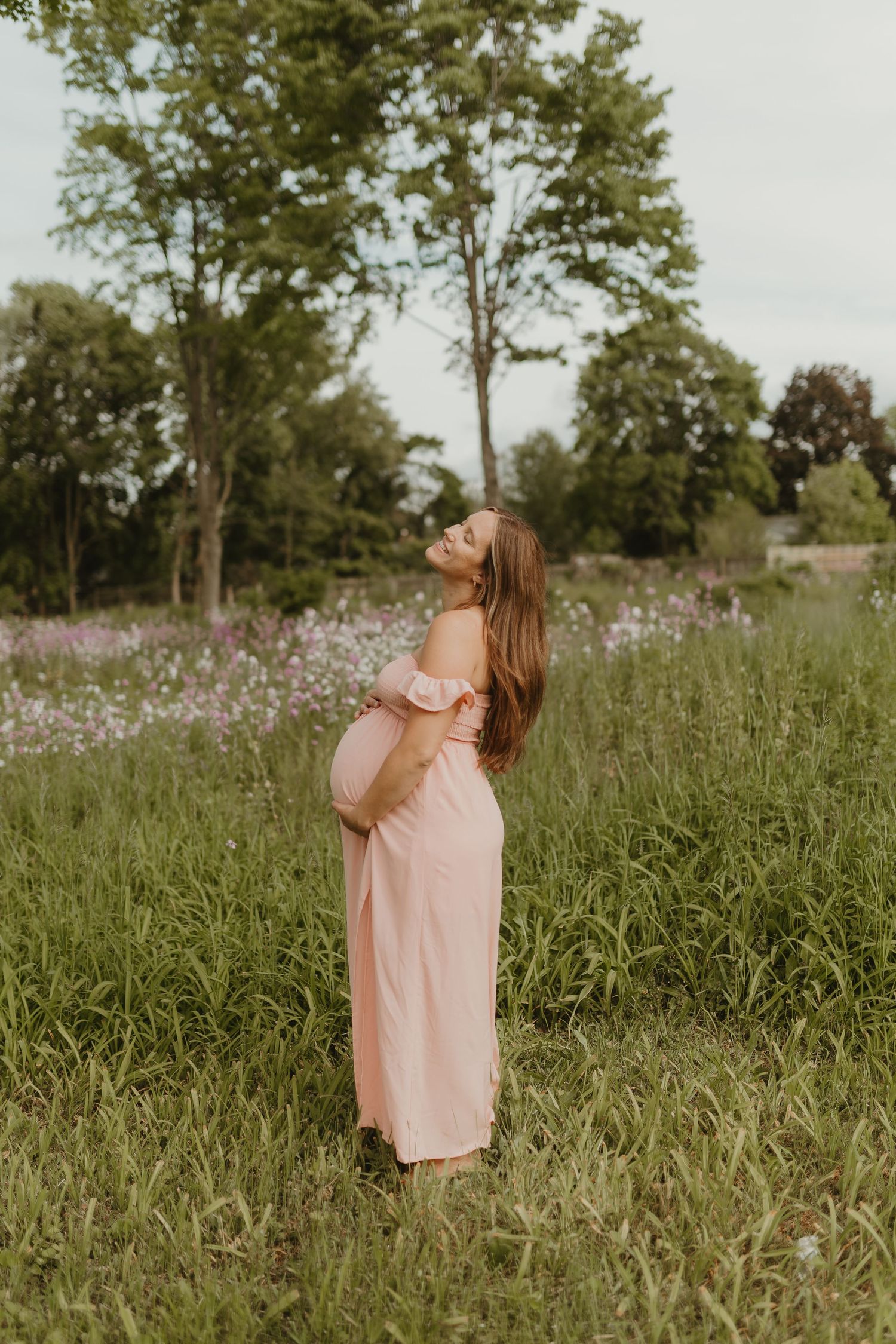 A dreamy maternity portrait in a field of wildflowers during golden hour.
