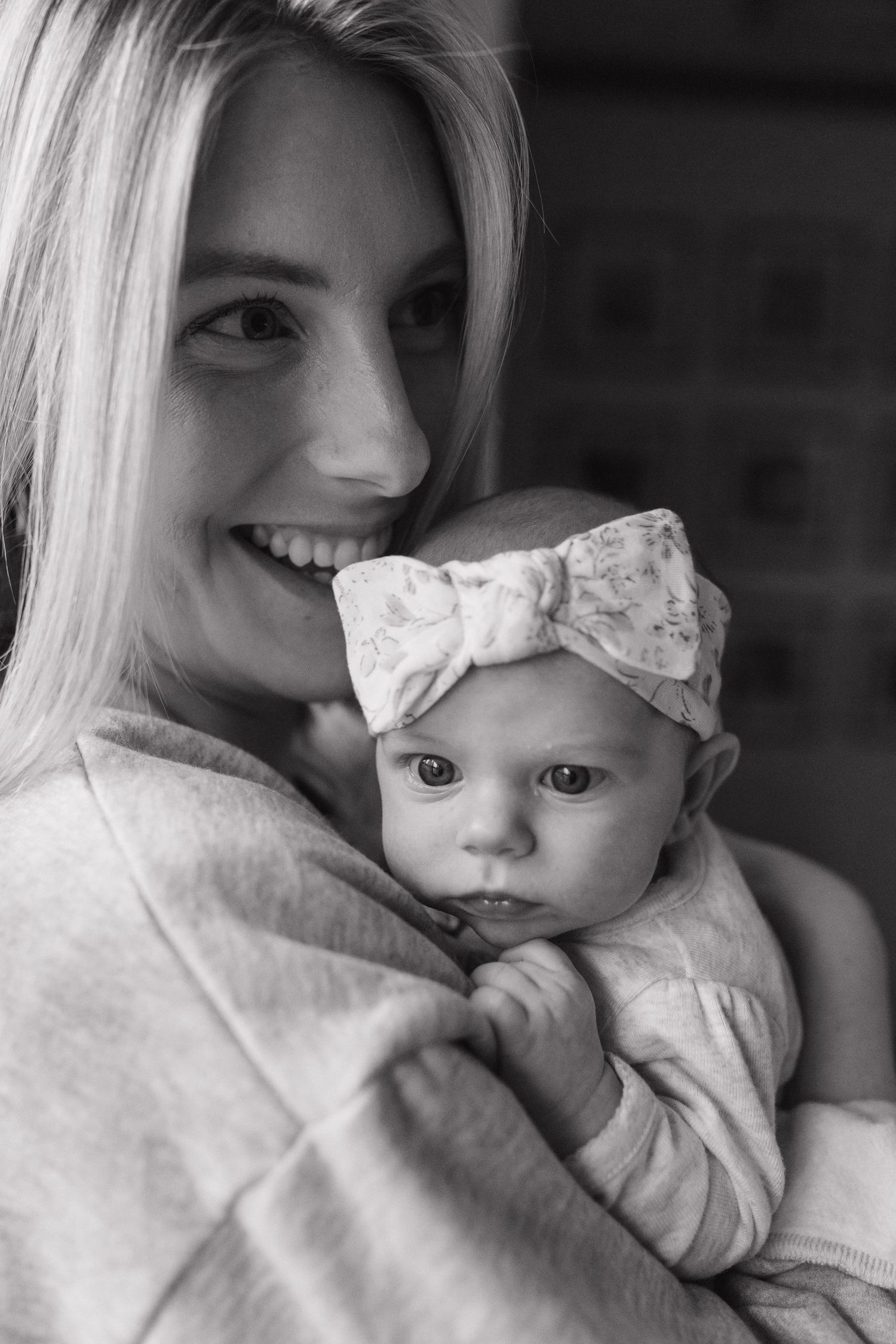 A tender black and white portrait of a parent and baby sharing affectionate moments.