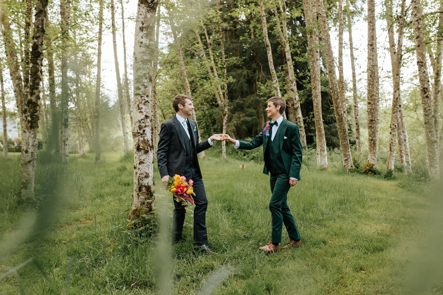 A group walks through a misty evergreen forest setting during a wedding photoshoot in natural sunlight.