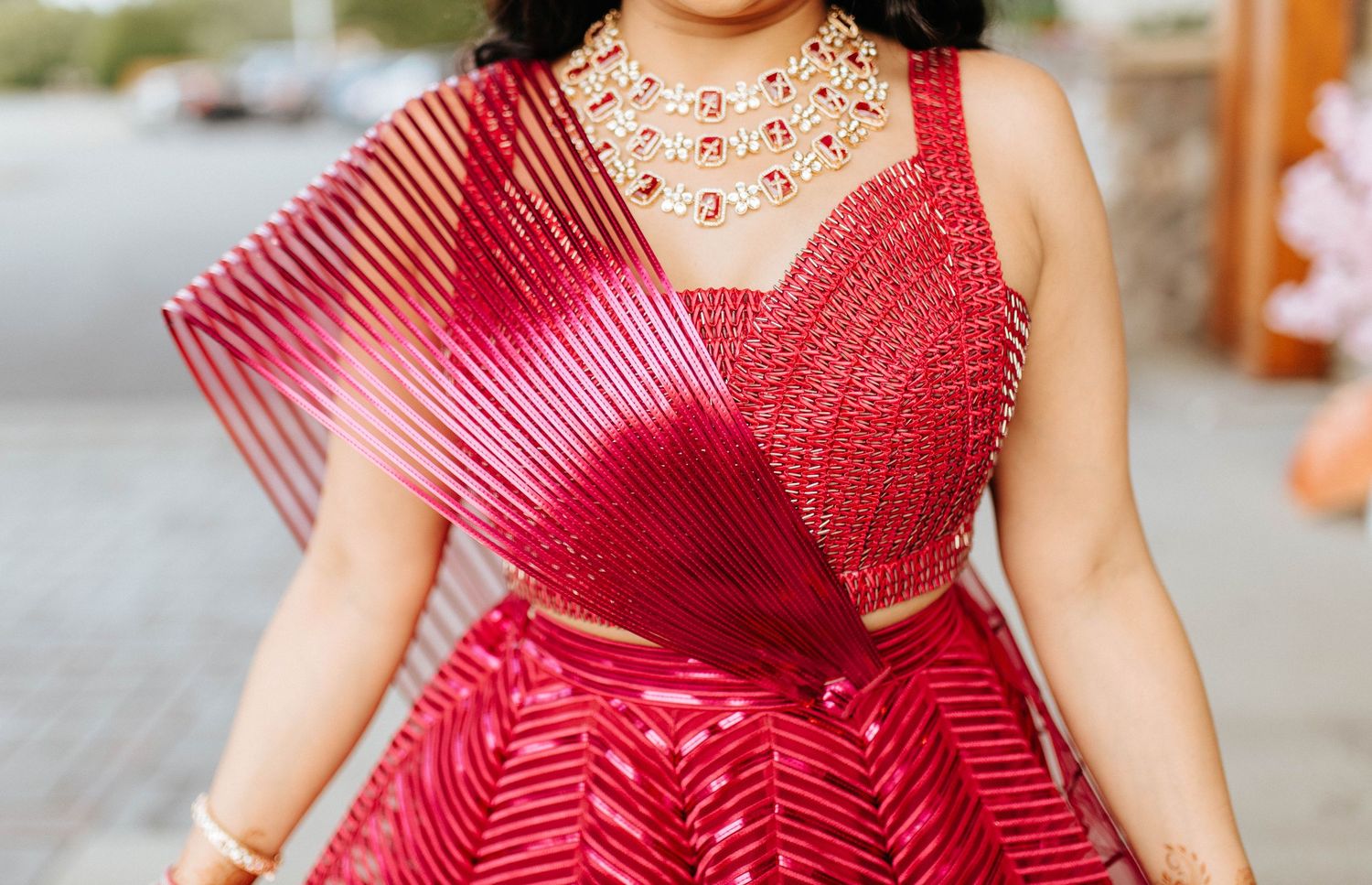 Close-up of bright red striped dress with pleated tulle overlay and embellished sweetheart neckline.