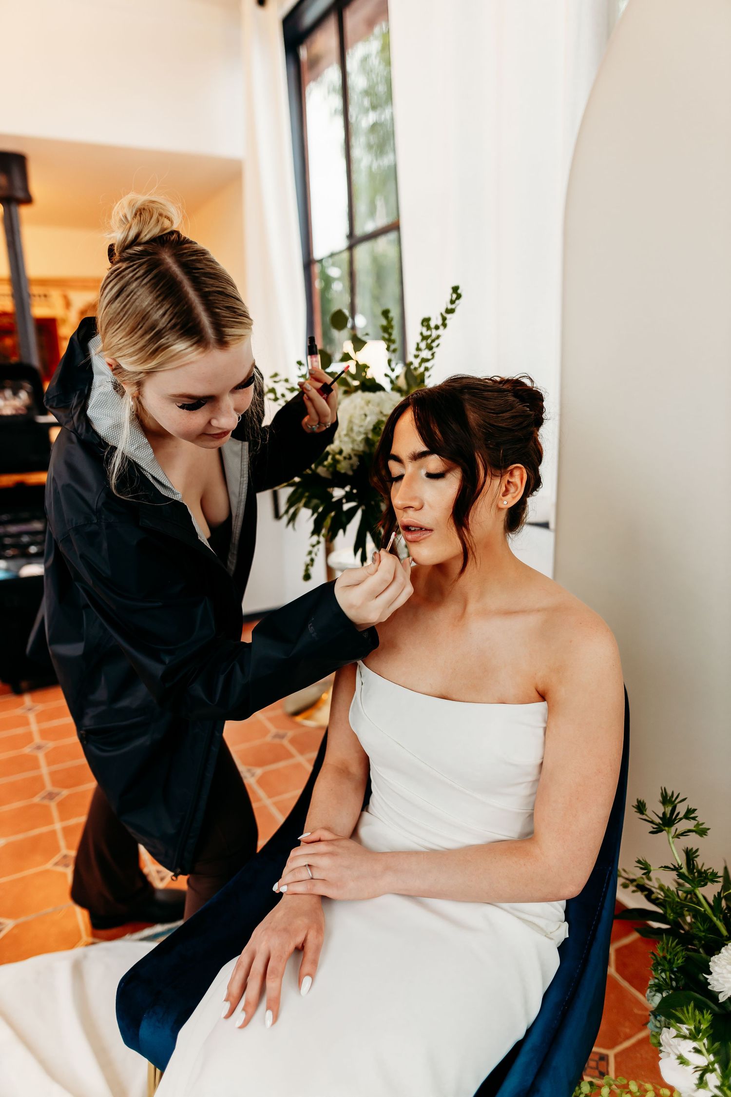 A bridal preparation moment showing final touches being made indoors.
