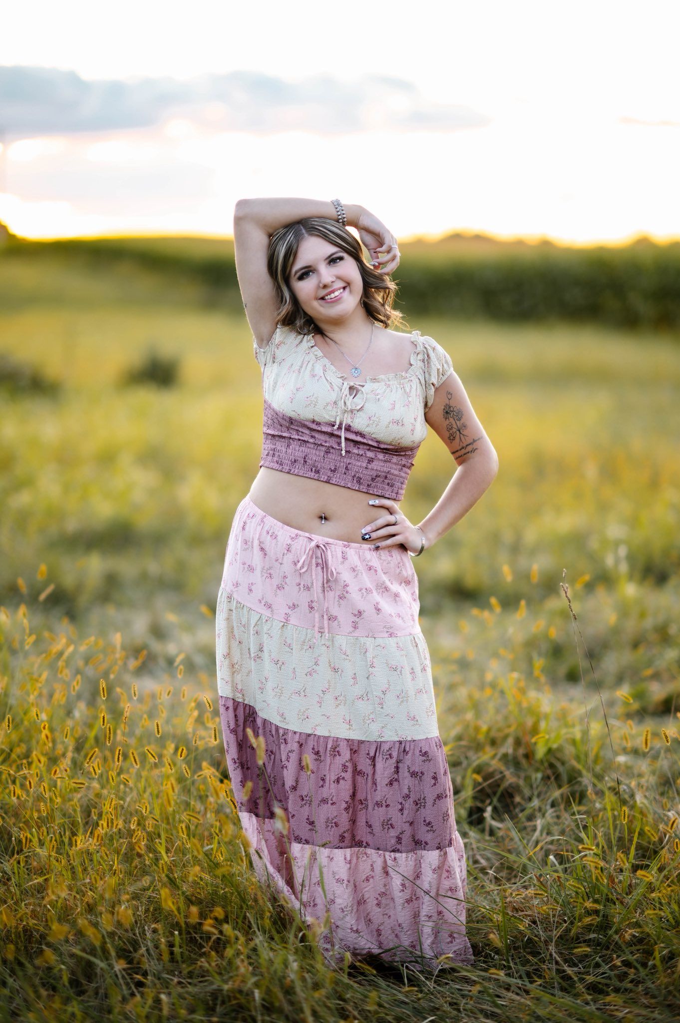 A floral maxi dress flows in the golden sunlit meadow during a summer photoshoot.