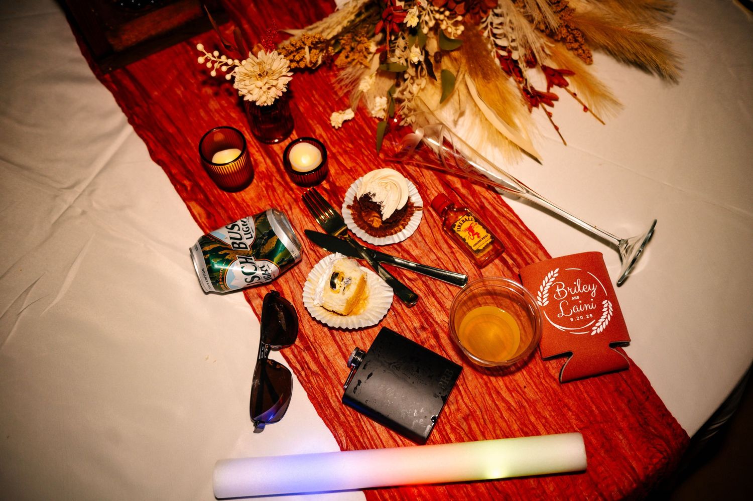 Wedding reception table decorated with candles, flowers and rustic details.